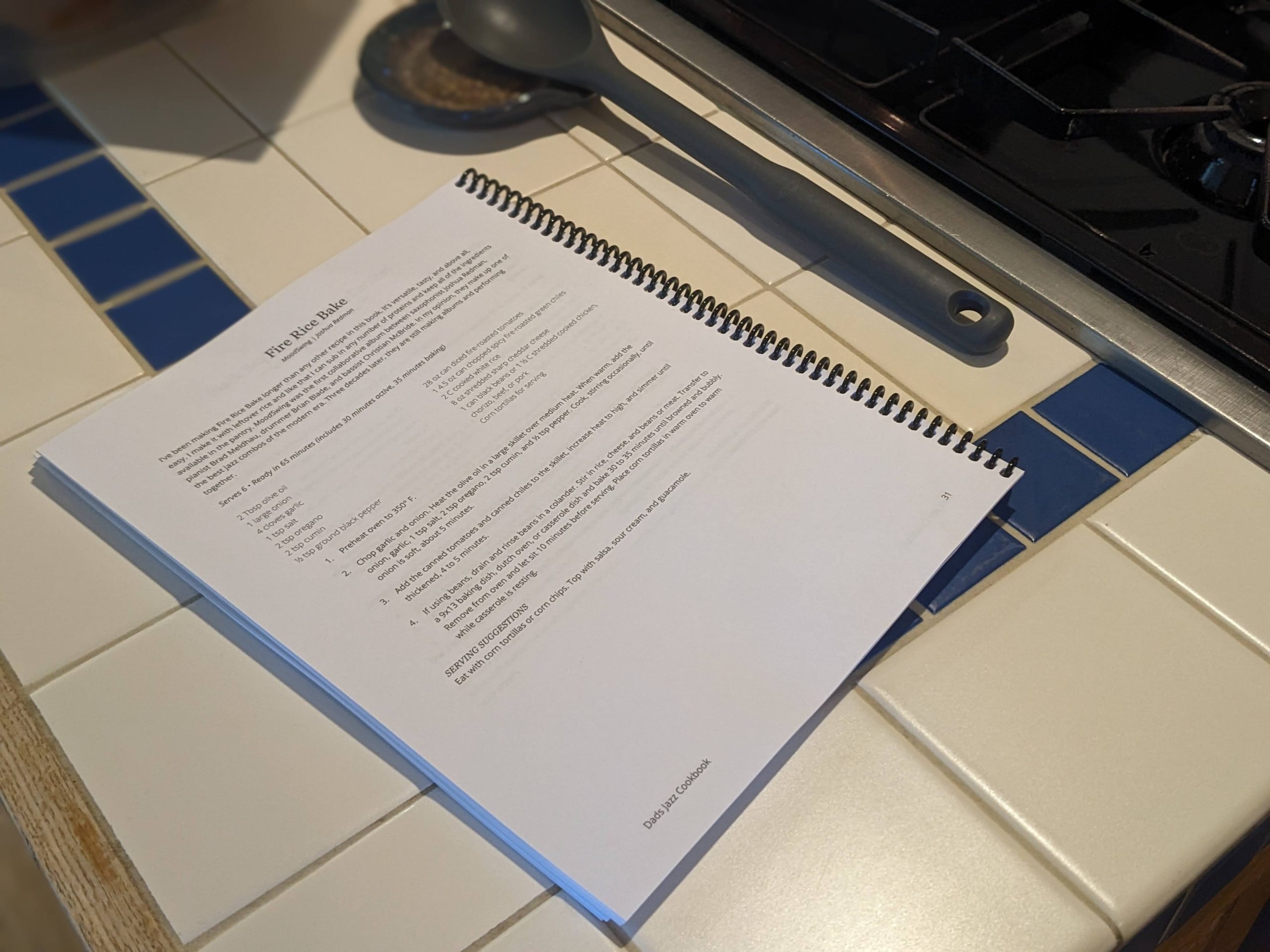 Dads jazz cookbook laying on a kitchen counter, open to the "Fire Rice Bake" recipe.