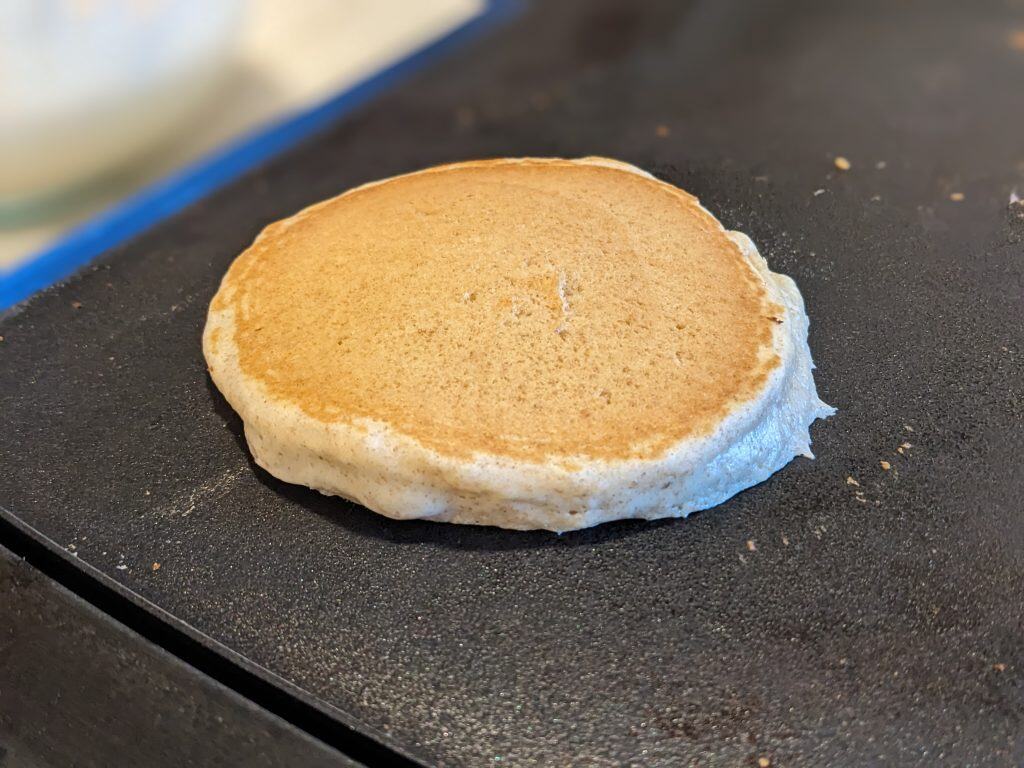 Pancake cooking on a nonstick electric griddle.