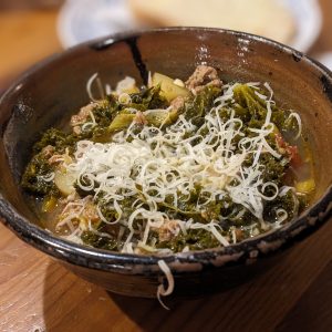 Kale Kielbasa Soup topped with Parmesan cheese